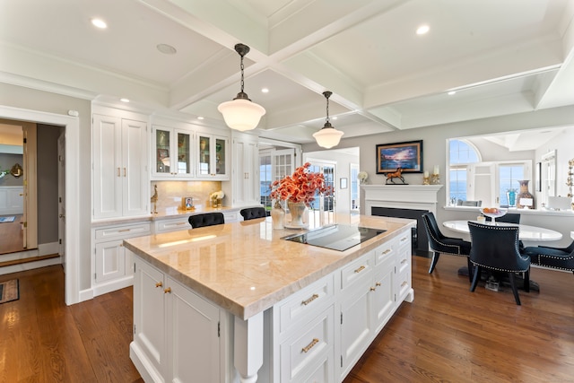 kitchen featuring white cabinetry, dark wood-type flooring, black electric stovetop, a kitchen island, and pendant lighting