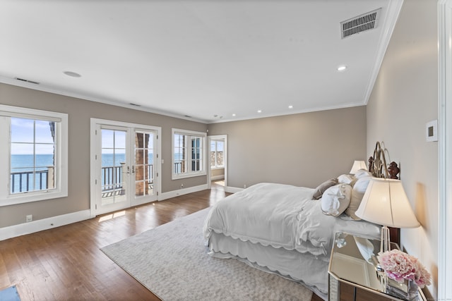 bedroom with access to exterior, french doors, hardwood / wood-style floors, and a water view