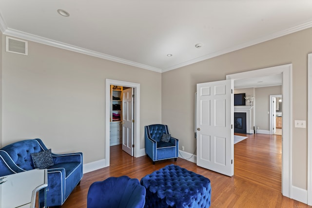 sitting room featuring ornamental molding and hardwood / wood-style flooring