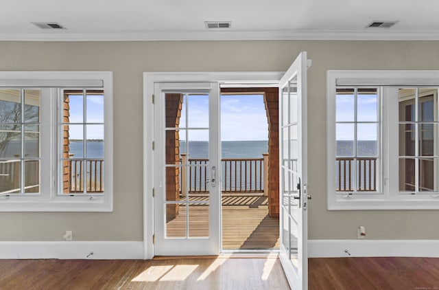 entryway with crown molding, french doors, a water view, and hardwood / wood-style floors