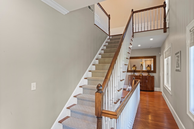 stairs featuring a high ceiling and hardwood / wood-style flooring