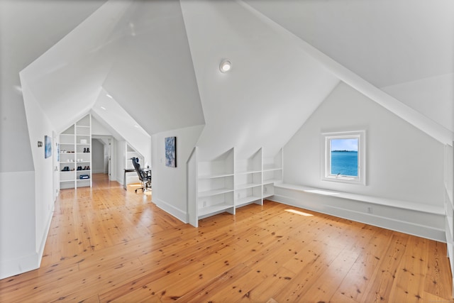 additional living space featuring lofted ceiling and light wood-type flooring