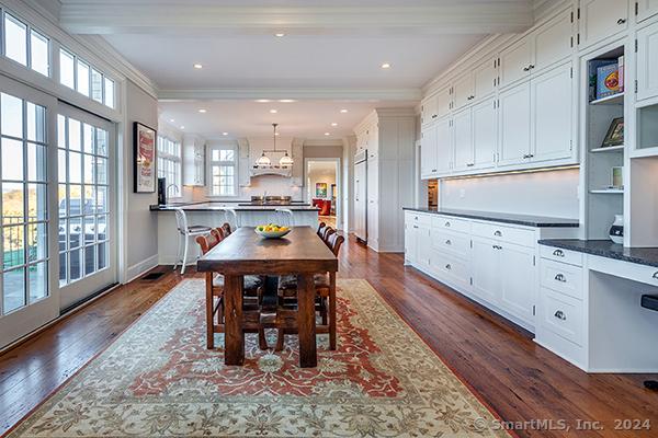 dining area featuring beam ceiling, dark wood-type flooring, and ornamental molding