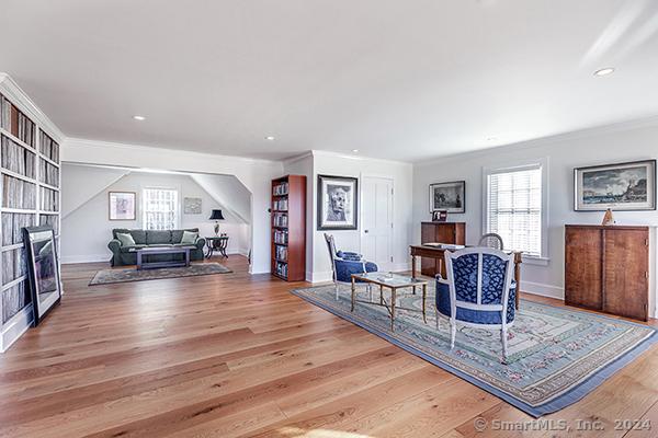 living room featuring crown molding and light hardwood / wood-style flooring