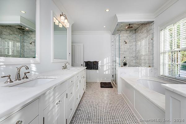 bathroom featuring vanity, ornamental molding, and plus walk in shower