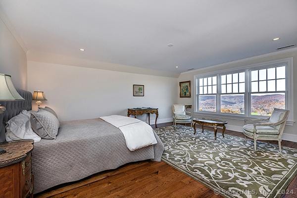 bedroom featuring ornamental molding and hardwood / wood-style flooring