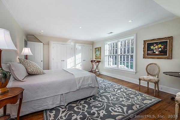 bedroom featuring crown molding and dark wood-type flooring