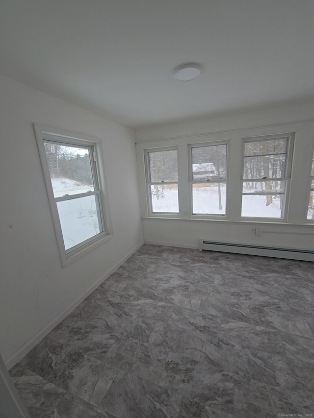 spare room featuring a baseboard radiator and plenty of natural light