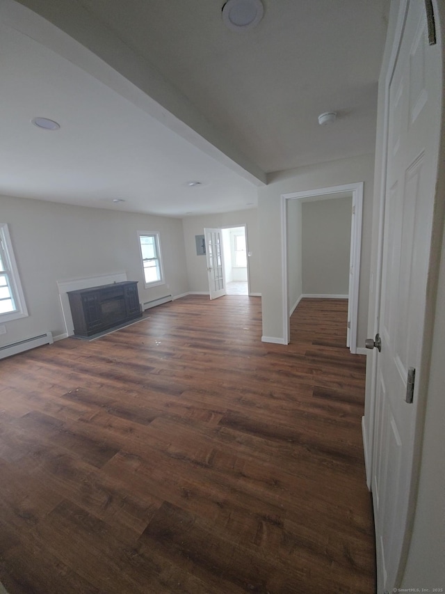 unfurnished living room featuring a baseboard heating unit and dark wood-type flooring