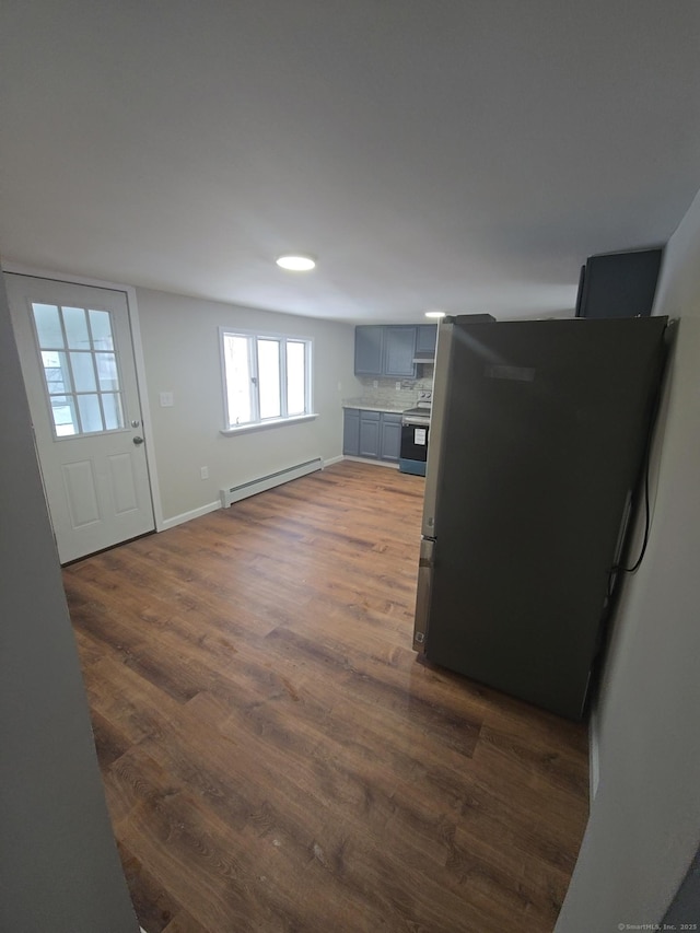 interior space with baseboard heating, stainless steel appliances, and dark hardwood / wood-style floors