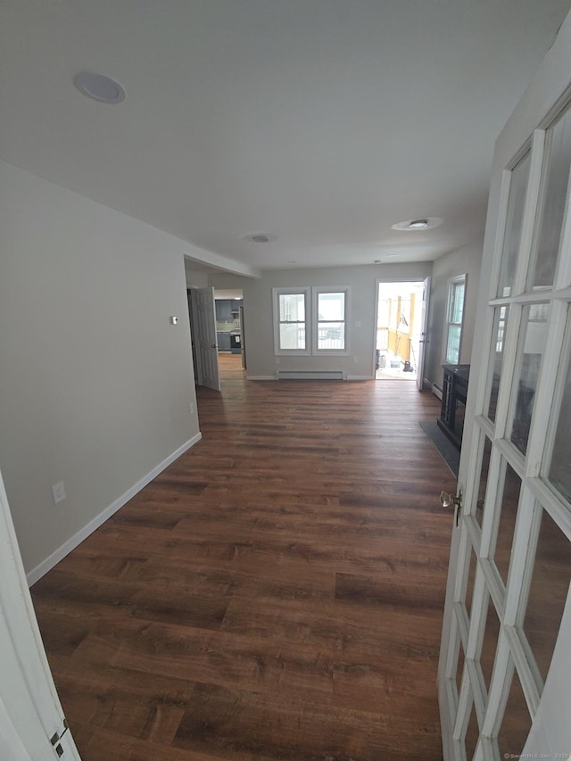 unfurnished room with dark hardwood / wood-style flooring and baseboard heating