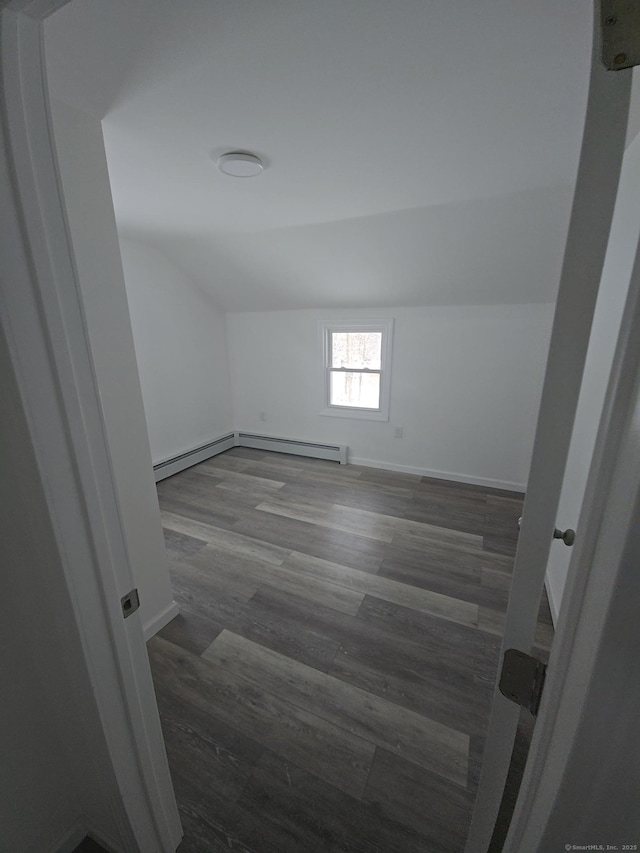 bonus room with baseboard heating, dark hardwood / wood-style floors, and lofted ceiling