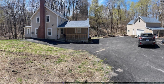 971 New Litchfield St, Torrington, CT 06790 - view of side of home with driveway, covered porch, a chimney, and an attached garage