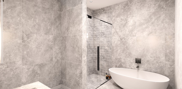 bathroom featuring shower with separate bathtub and tile walls