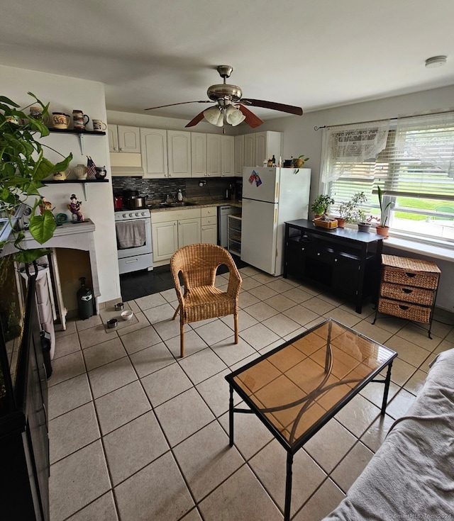 tiled living room with ceiling fan, sink, and beverage cooler