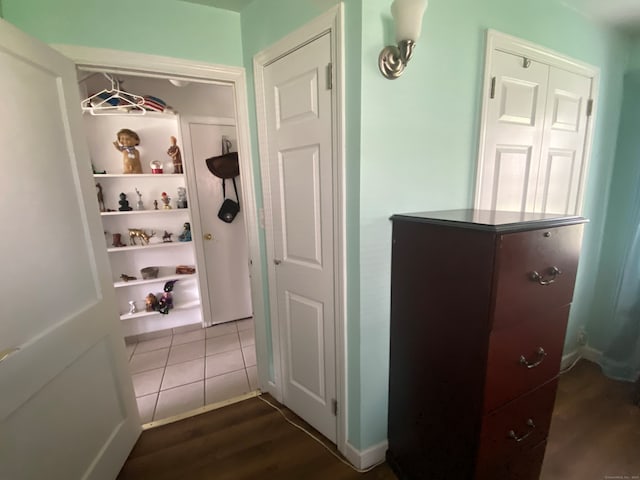 hall featuring dark tile flooring