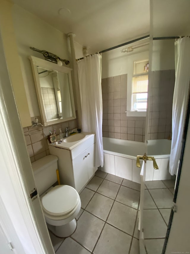 full bathroom featuring tile flooring, tile walls, toilet, vanity, and shower / bathtub combination with curtain