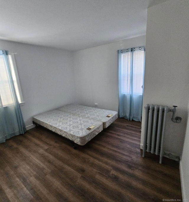 bedroom featuring radiator and dark hardwood / wood-style floors