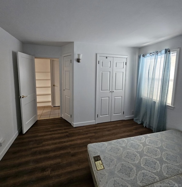 unfurnished bedroom with a closet and dark hardwood / wood-style flooring