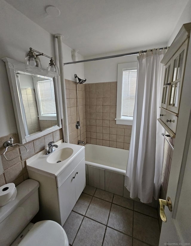 full bathroom with tile walls, vanity, shower / bathtub combination with curtain, toilet, and tile patterned floors