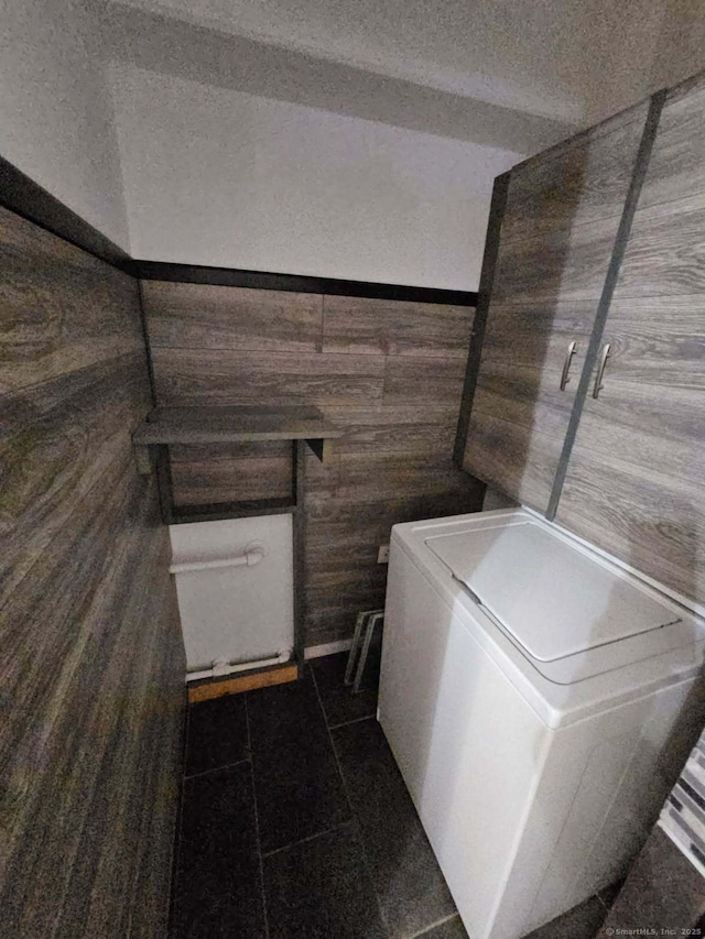 washroom with washer / dryer and dark tile patterned flooring