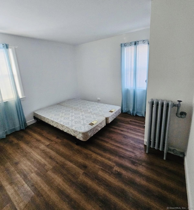 357 Granfield Ave Unit B, Bridgeport, CT 06610 - bedroom featuring radiator, multiple windows, and dark wood-type flooring