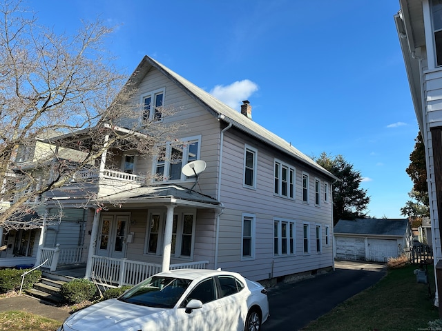 view of front of house with an outbuilding, a garage, and covered porch