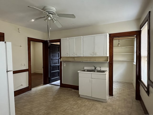 kitchen featuring a healthy amount of sunlight, white cabinetry, sink, and white fridge