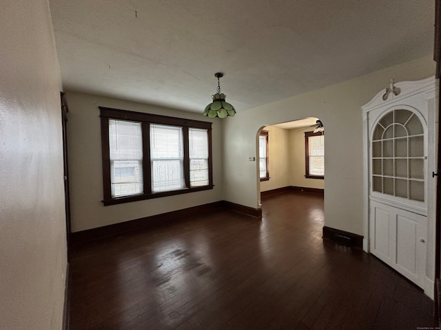 empty room with ceiling fan and dark hardwood / wood-style floors