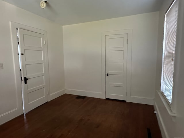 empty room with dark hardwood / wood-style flooring