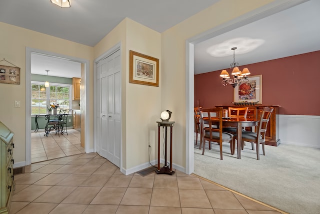 dining area featuring light carpet and an inviting chandelier