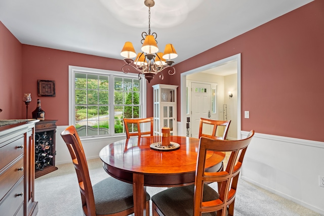 carpeted dining room with a notable chandelier