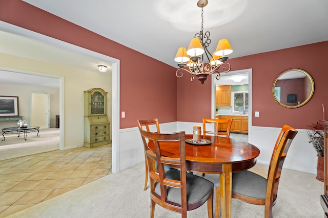 dining room with light carpet and a chandelier