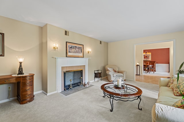 carpeted living room with a tile fireplace