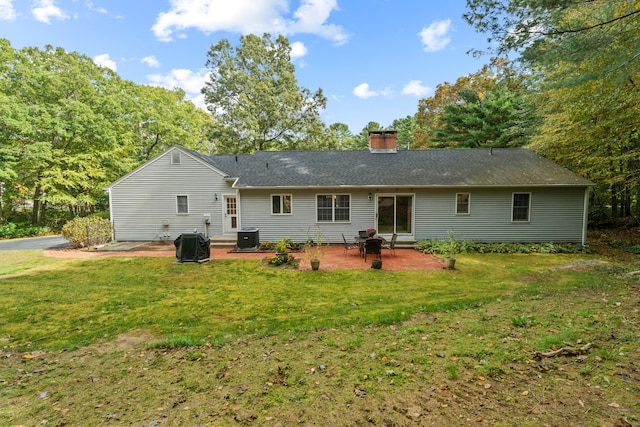 back of property with a lawn, a patio, and central air condition unit