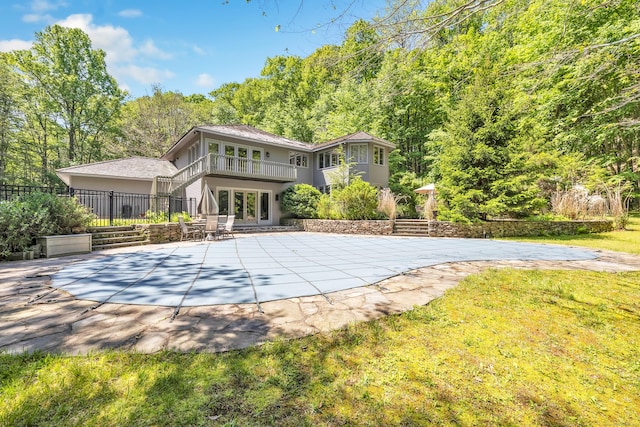 back of house featuring a balcony, a patio, and a covered pool