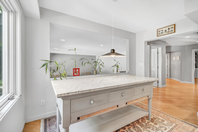 kitchen with light stone countertops and light wood-type flooring