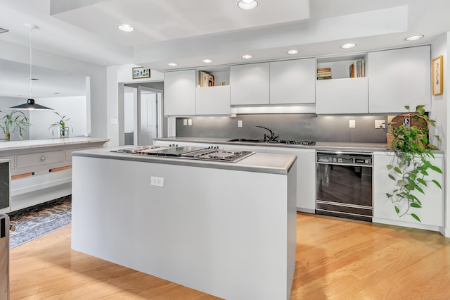 kitchen featuring white cabinetry, sink, light hardwood / wood-style flooring, and black dishwasher