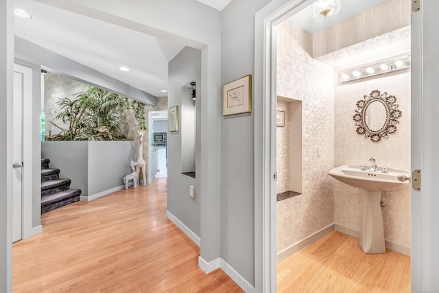 corridor with sink and light hardwood / wood-style floors