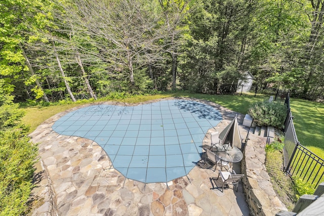 view of pool with a lawn and a patio