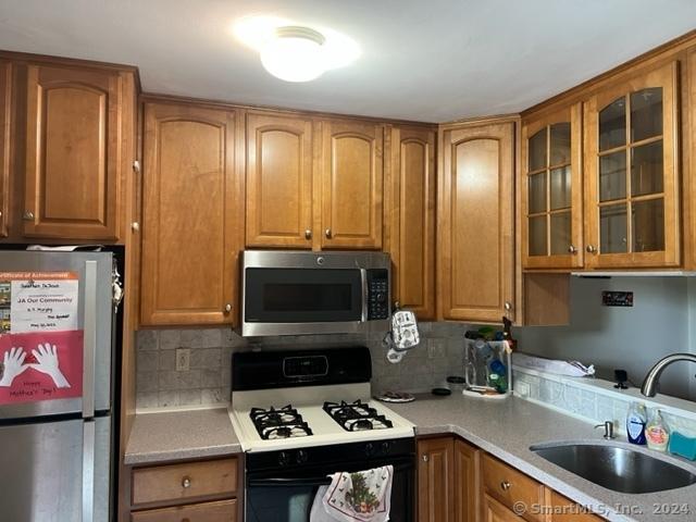 kitchen with backsplash, sink, and stainless steel appliances