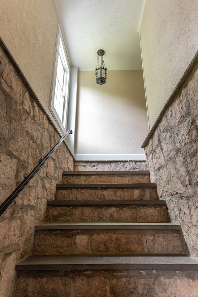 stairs featuring a textured ceiling