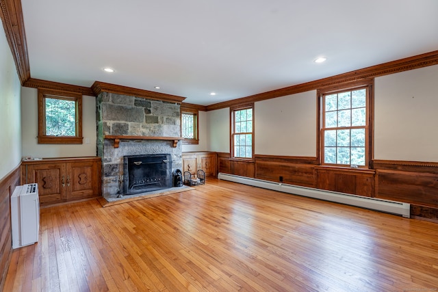 unfurnished living room with a stone fireplace, a baseboard radiator, light hardwood / wood-style flooring, and crown molding