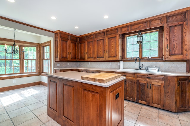 kitchen with light tile flooring, a healthy amount of sunlight, tasteful backsplash, a center island, and pendant lighting