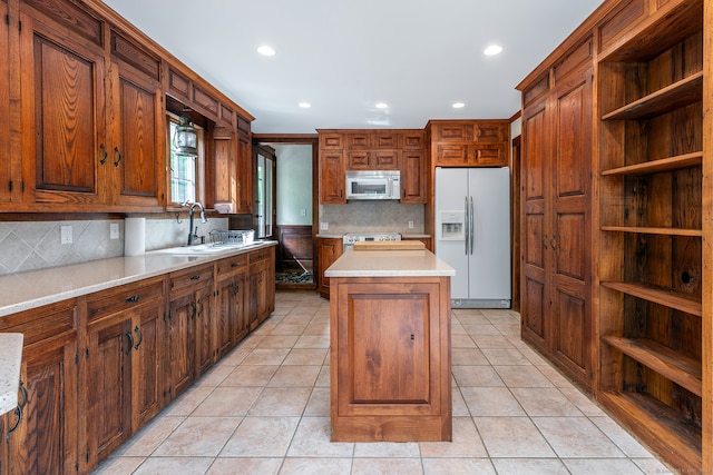 kitchen featuring tasteful backsplash, light tile flooring, a kitchen island, and white refrigerator with ice dispenser