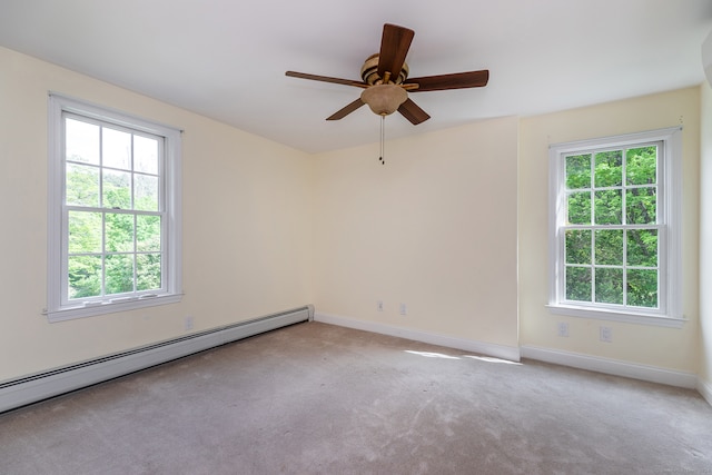 carpeted spare room with a baseboard heating unit, plenty of natural light, and ceiling fan