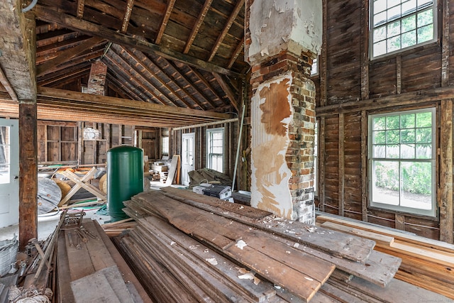 misc room with high vaulted ceiling, wood-type flooring, brick wall, and wood ceiling