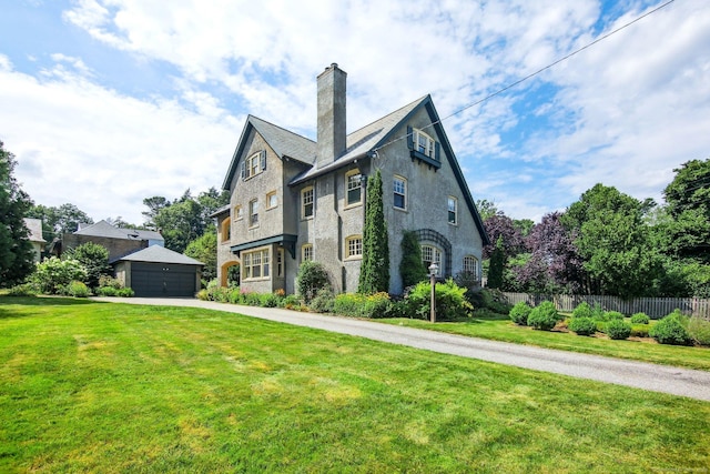 tudor-style house with a garage and a front lawn