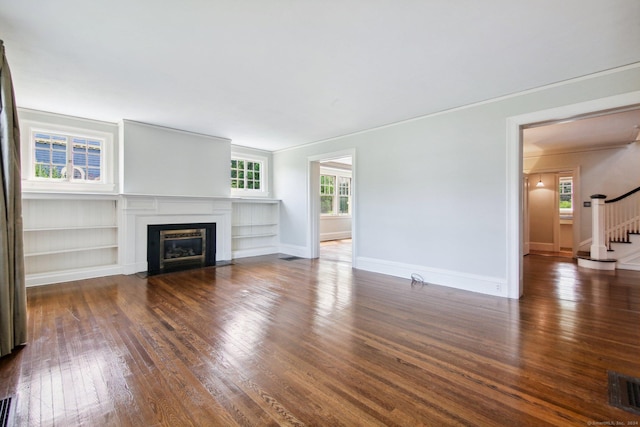 unfurnished living room with built in features and dark hardwood / wood-style flooring