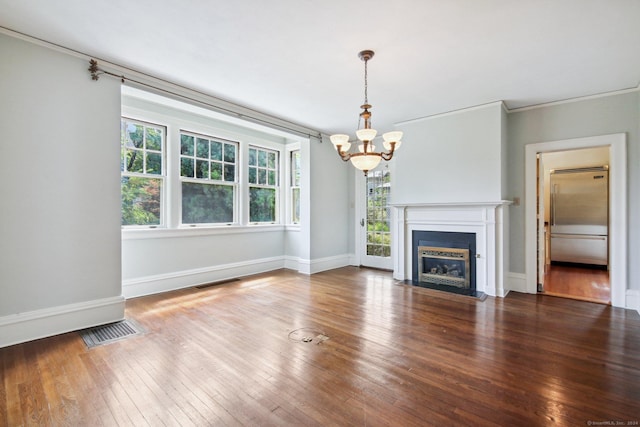 unfurnished living room with wood-type flooring, crown molding, and an inviting chandelier